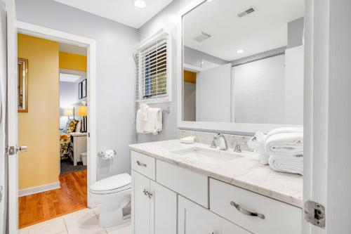 Baño blanco con lavabo y aseo en Inlet Cove 11, en Kiawah Island