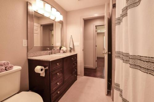 a bathroom with a sink and a toilet and a mirror at Old Town Bungalow - 4 blocks to Historic Square in Georgetown