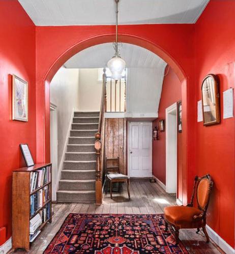 a hallway with red walls and a staircase with a stair case at Bothwell Hotel of the Highlands in Bothwell