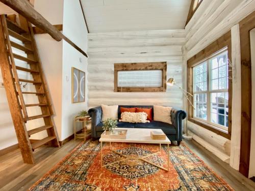 sala de estar con sofá azul y alfombra en Black Bear Cabin 1 en Whitefish