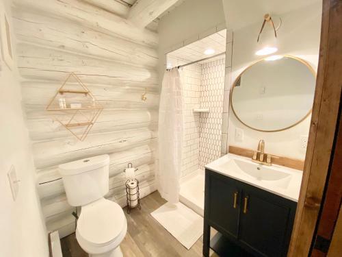 y baño con aseo, lavabo y espejo. en Black Bear Cabin 1 en Whitefish
