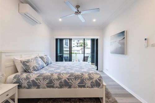 a bedroom with a bed and a ceiling fan at Beach Haven 3a Messines Street 4 Minute walk to the beach Wifi Air Con in Shoal Bay