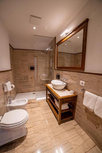 a bathroom with a toilet and a sink and a shower at VILLA PERMET in Përmet