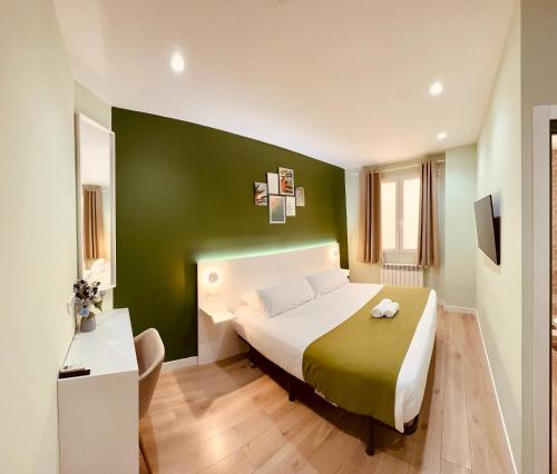マドリードにあるオスタル アバディア マドリードの緑の壁のベッドルーム1室(大型ベッド1台付)