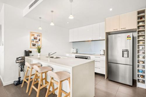 a kitchen with white cabinets and a kitchen island with stools at Penthouse Bridgeview San Remo in San Remo