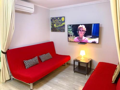 ロスピタレート・デ・リョブレガートにあるCamp Nou, Europa Fira - modern two-bedroom apartment with heatingのリビングルーム(赤いソファ、テレビ付)