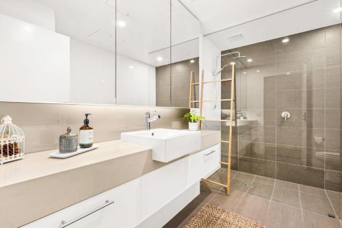 Penthouse Bridgeview San Remo في سانريمو: حمام أبيض مع حوض ودش