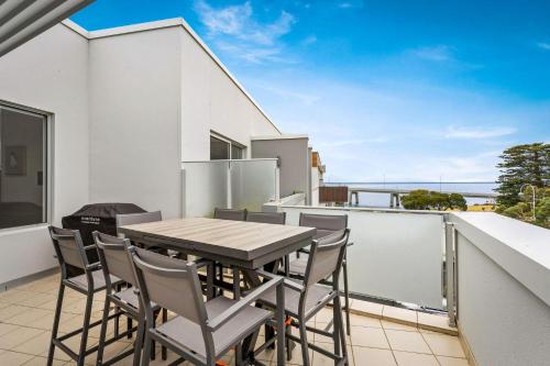 a table and chairs on the balcony of a house at Penthouse Bridgeview San Remo in San Remo