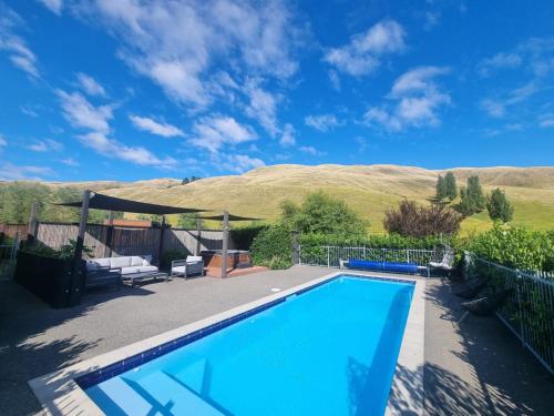 una piscina en un patio con montañas al fondo en Savana Estate, en Poukawa