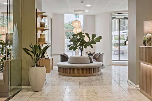 a lobby with a round table with plants in it at Hotel Svendborg in Svendborg