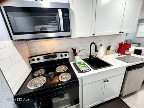a kitchen with a stove and a microwave at Studio 3! in Lakeland