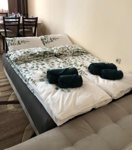 two beds with green pillows on them in a bedroom at Luxury apartment 2 Free Underground Secure Parking in Pazardzhik
