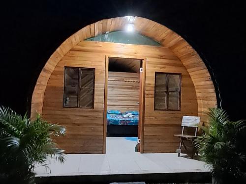 um chalé de madeira com uma porta e uma cama em tayrona breeze em Santa Marta