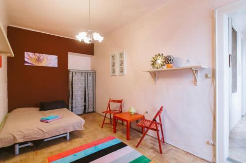 ブダペストにあるComedy Apartmentのベッド、テーブル、椅子が備わる客室です。