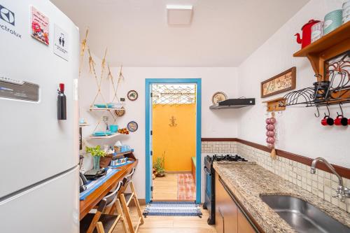 a kitchen with a sink and a yellow door at CasinhaPiri in Pirenópolis