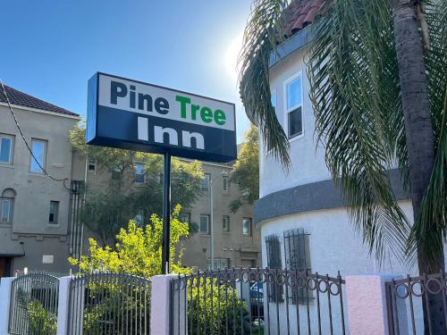 a pine tree inn sign in front of a fence at Pine tree inn in Los Angeles