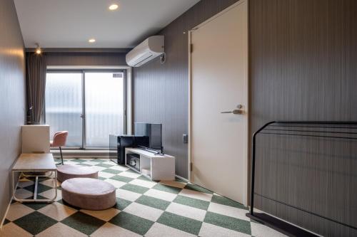 a room with a bedroom with a bed and a tv at Granrina Kanazawa - Female only apartment hotel in Kanazawa
