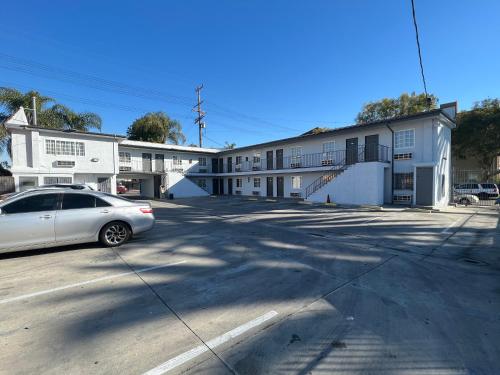 a white car parked in front of a building at Pine tree inn in Los Angeles