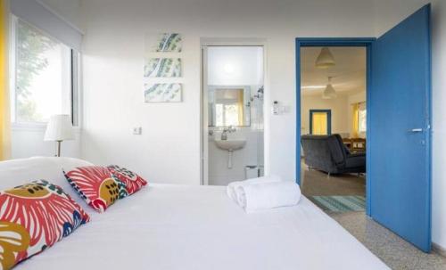 a bedroom with a large white bed and a bathroom at Hollyday & vacation in Beit Hillel