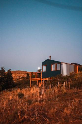 a tiny house sitting on top of a field at Cuatro Vientos Patagonia - Lago Huechulafquen in Junín de los Andes