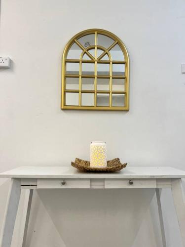 una mesa con sombrero y un espejo en la pared en Roemah lily studio, en Tanah Rata