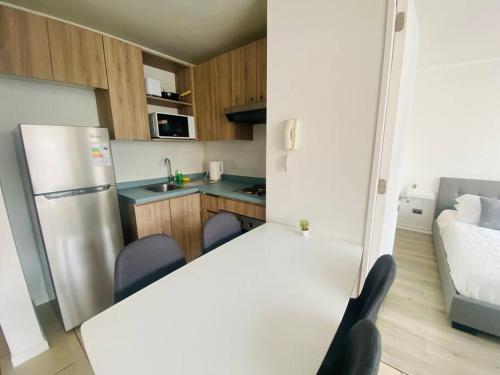 a small kitchen with a refrigerator and two chairs at Acogedor apartamento en Santiago 1D1B in Santiago