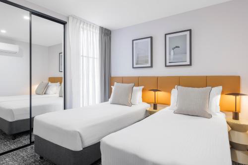 a hotel room with two beds and a window at Punthill Essendon North in Melbourne