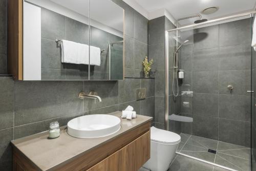 a bathroom with a sink and a toilet and a shower at Punthill Essendon North in Melbourne