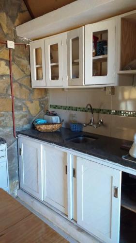 a kitchen with white cabinets and a sink at Filippo in Zapala