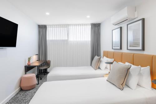 a hotel room with two beds and a tv at Punthill Essendon North in Melbourne
