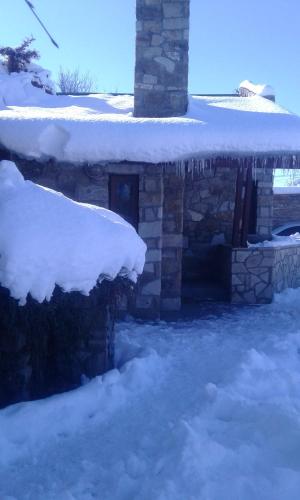 un bâtiment en pierre avec de la neige au-dessus dans l'établissement Filippo, à Zapala