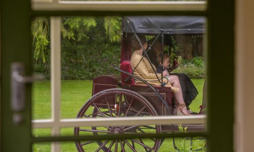 a woman is sitting in a horse drawn carriage at Hemsworth Estate in Elgin