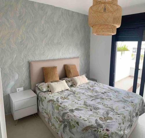 a bedroom with a large bed with a floral bedspread at Penthouse 2-Rooms with Private Jacuzzi in the Solarium in Orihuela Costa