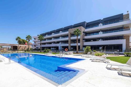a swimming pool in front of a building at Penthouse 2-Rooms with Private Jacuzzi in the Solarium in Orihuela Costa