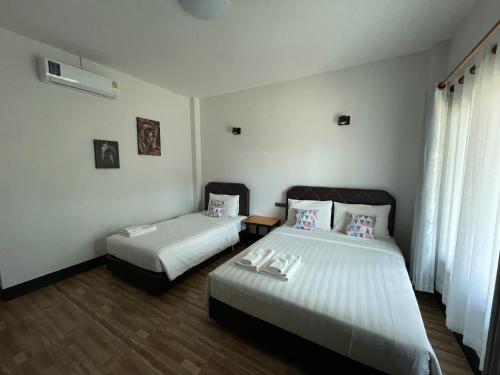 Postel nebo postele na pokoji v ubytování Jeerat House จิรัสเฮ้าส์