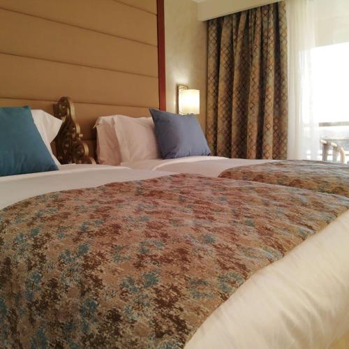 a hotel room with two beds and a window at Nile Cruise 3 nights From Aswan to Luxor Every Friday, Monday and Wednesday with tours in Jazīrat al ‘Awwāmīyah