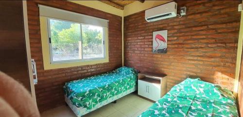 ein kleines Zimmer mit zwei Betten und einem Fenster in der Unterkunft Cabaña Villa Tacú in Zonda