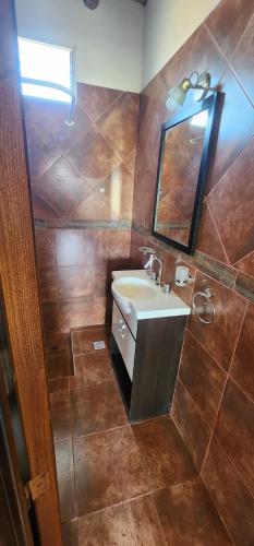 ein Badezimmer mit Waschbecken und Spiegel in der Unterkunft Cabaña Villa Tacú in Zonda