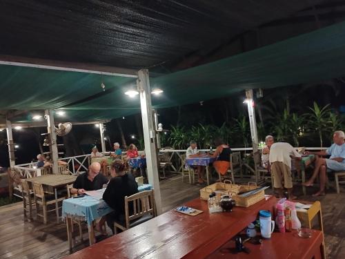 a group of people sitting at tables under a tent at Sukorn Andaman Beach Resort in Ko Sukon