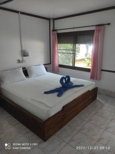 a bedroom with a bed with a ribbon on it at Sukorn Andaman Beach Resort in Ko Sukon
