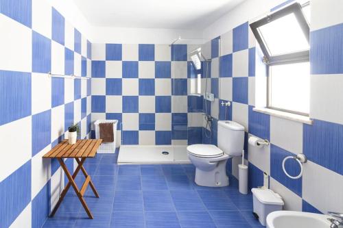 a blue and white bathroom with a toilet and a sink at Casa Levante in Sagres