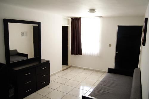 a bedroom with a mirror and a dresser and a window at Hotel del Alba Inn & Suites in Aguascalientes