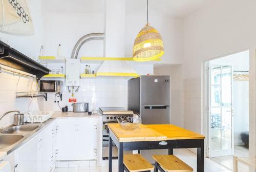 a kitchen with white cabinets and a wooden table at Casa Levante in Sagres