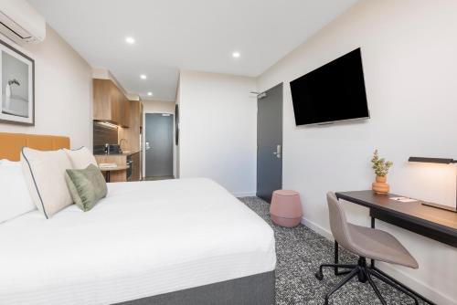 a hotel room with a bed and a desk at Punthill Essendon North in Melbourne
