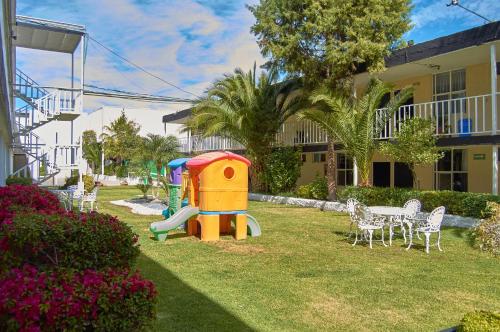 a playground in a yard next to a house at Hotel del Alba Inn & Suites in Aguascalientes