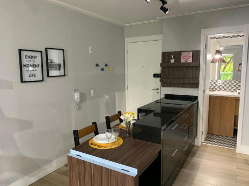 a kitchen with a wooden table and a black refrigerator at Modernidade e conforto para sua hospedagem !!! in Sao Paulo