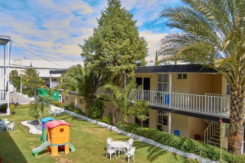 a yard with a playground and a house at Hotel del Alba Inn & Suites in Aguascalientes