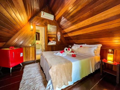 a bedroom with a bed in a wooden cabin at Chez Max Pousada in Morro de São Paulo