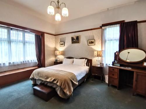 Hemsworth Estate في Elgin: غرفة نوم بسرير وغطاء ومرآة