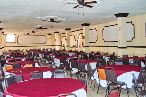 a banquet hall with red and white tables and chairs at Hotel del Alba Inn & Suites in Aguascalientes